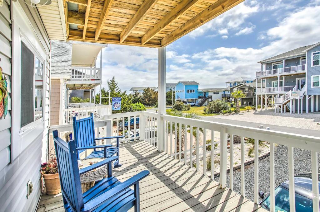 a balcony with two blue chairs on a house at Coastal Oasis with Decks Walk to Holden Beach! in Holden Beach