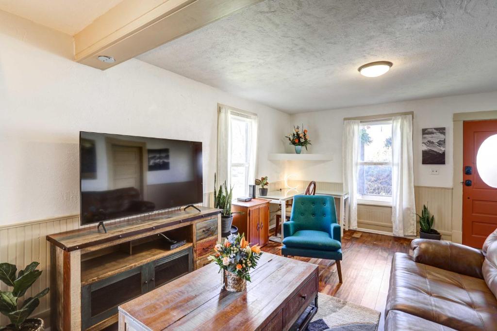 uma sala de estar com uma televisão, um sofá e uma mesa em Charming Montrose Family Home Block to Downtown! em Montrose