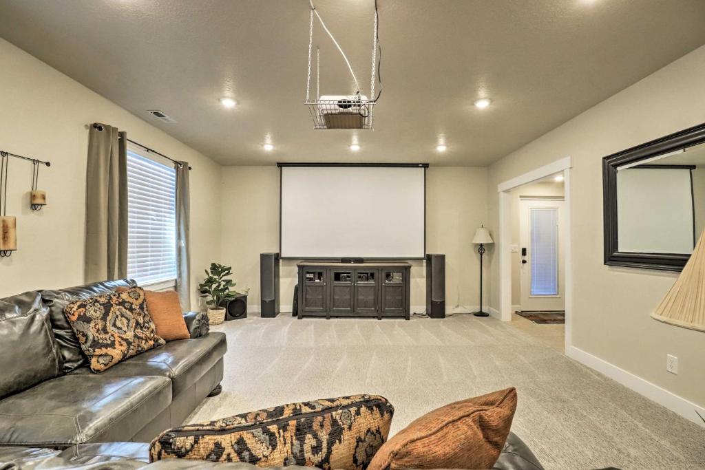 a living room with a couch and a large screen at Contemporary Home with Grill Near Utah Lake! in Saratoga Springs