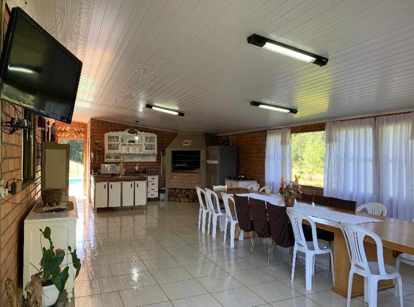 cocina y comedor con mesa y sillas en Sítio com Piscina e Vista a 12km de Treze Tílias, en Ibicaré