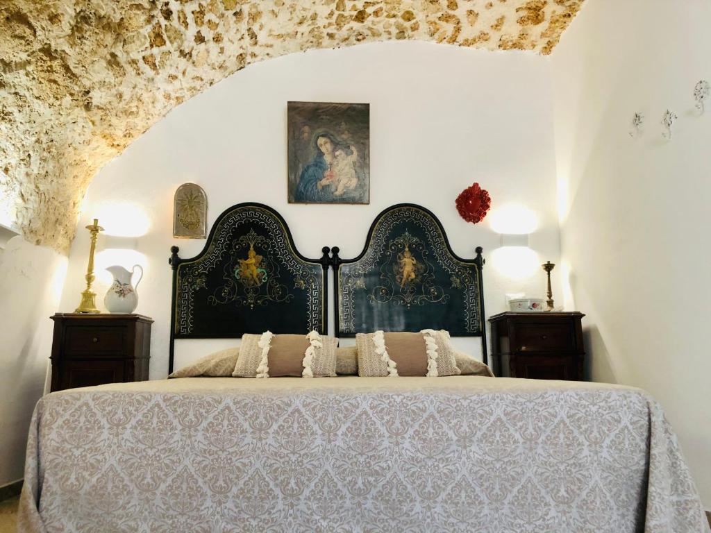 a bedroom with a large bed in a room at Dimora Umberto - Dammuso Suite in Noto