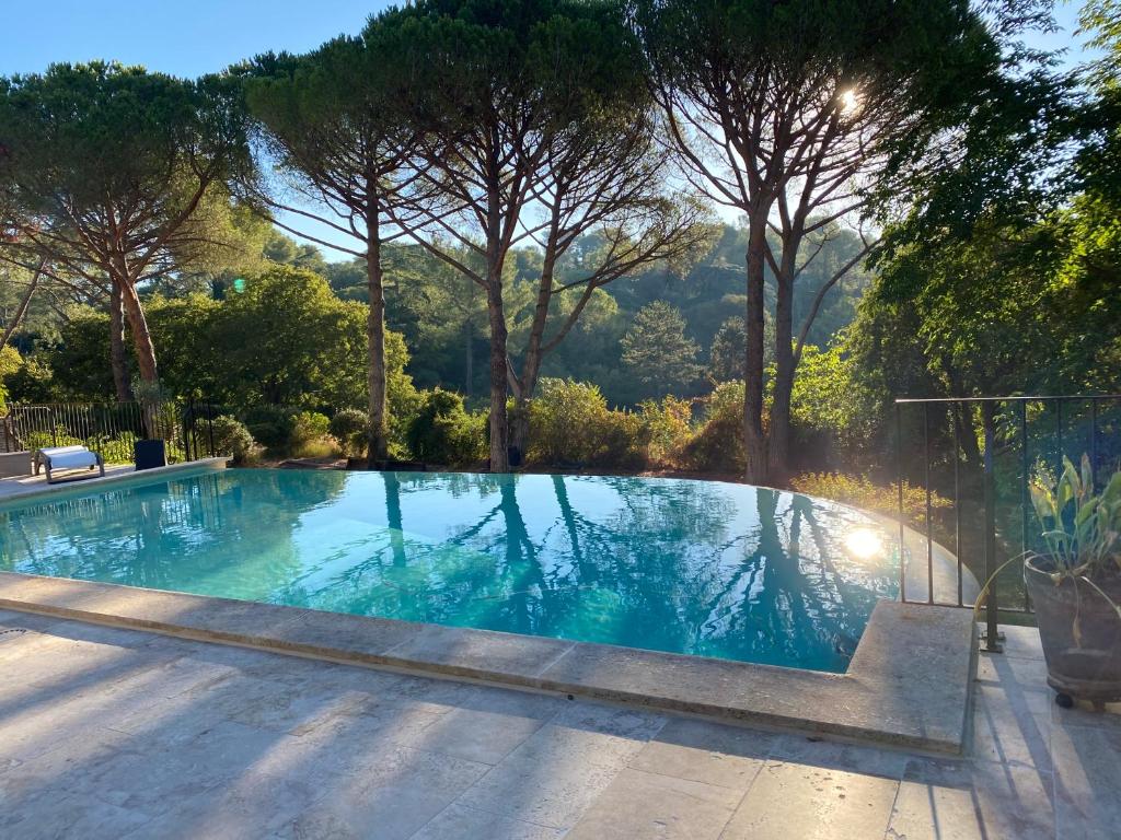 una gran piscina con árboles en el fondo en Guest House Encantada, en Nimes