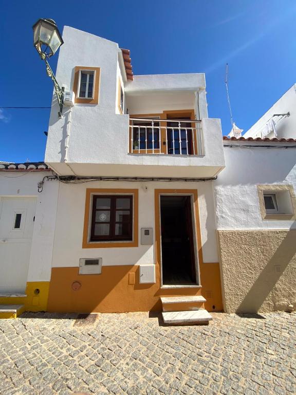 a white and yellow house with a balcony at Lagos Center House in Lagos