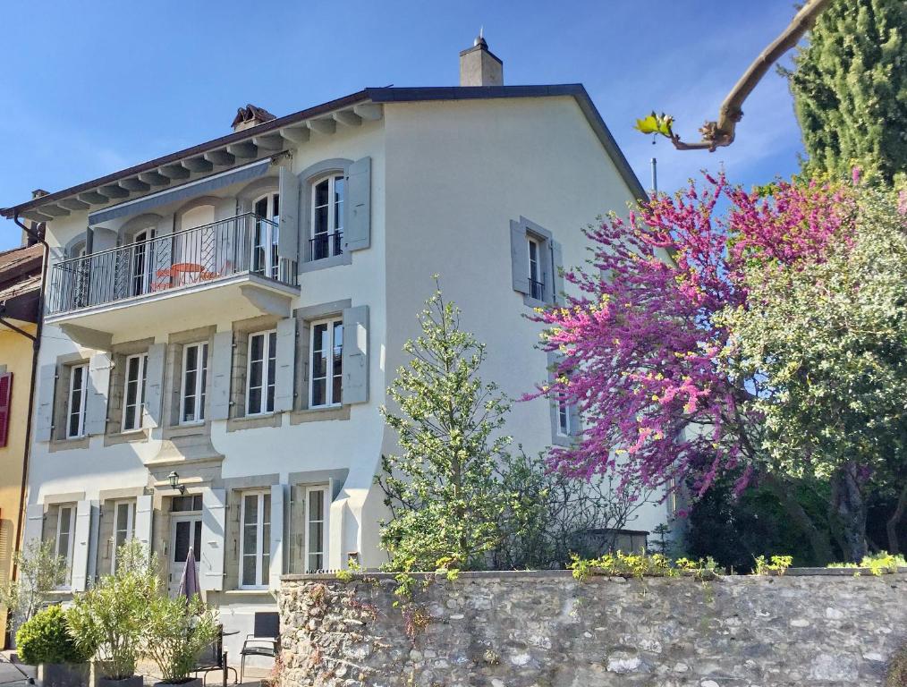 a white house with a fence and trees at Le Cinquante Quatre in Perroy