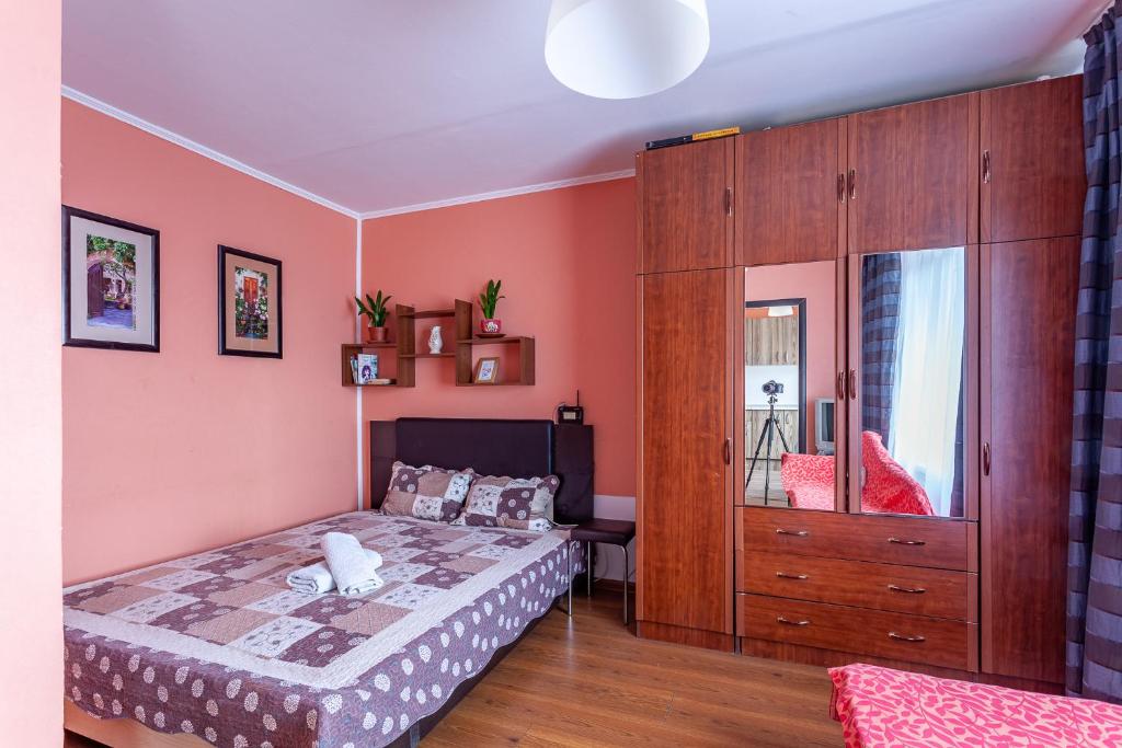 莫斯科的住宿－梅尼科瓦越橘無產階級公寓，一间卧室配有一张床和一个木制橱柜