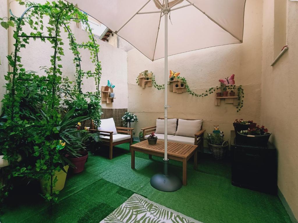 ニースにあるNice appartement cosy + patio privéのパティオ(植物、テーブル、傘付)