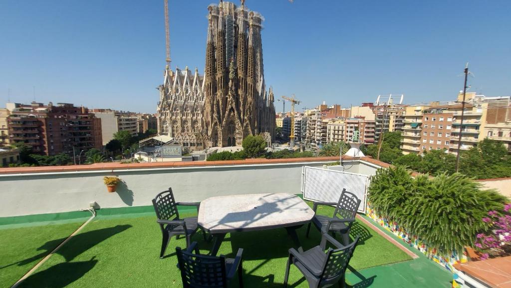 eine Terrasse mit einem Tisch und Stühlen auf dem Dach in der Unterkunft Absolute Sagrada Familia in Barcelona