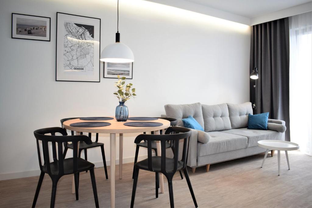 a living room with a table and a couch at Apartos Apartamenty Grano Residence in Gdańsk