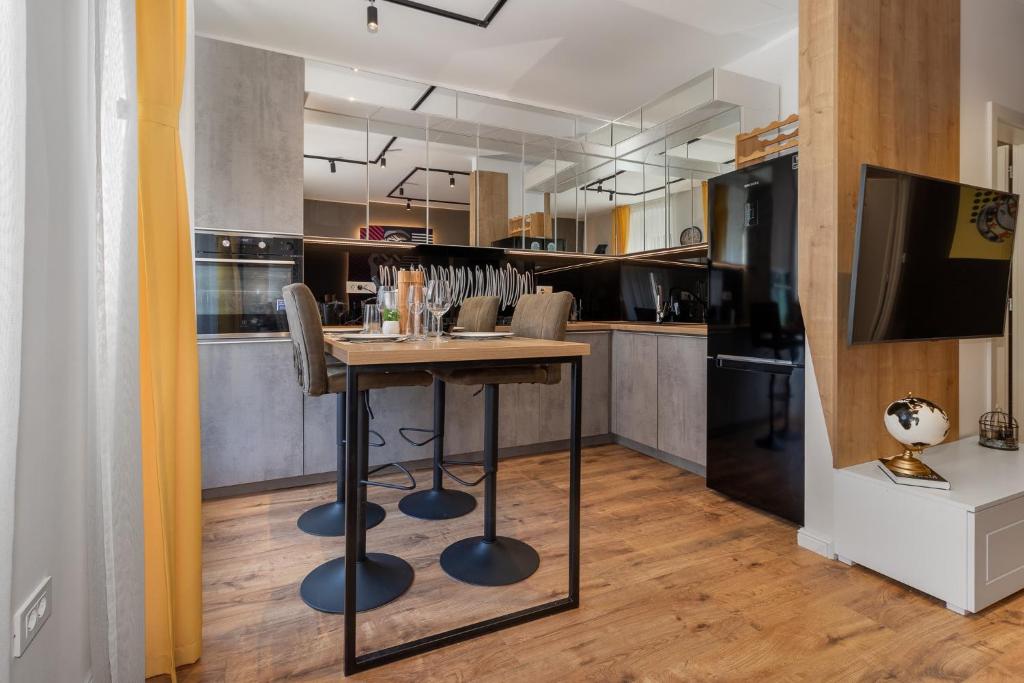 uma cozinha com uma mesa com cadeiras e uma televisão em Apartments BARBIS em Rijeka