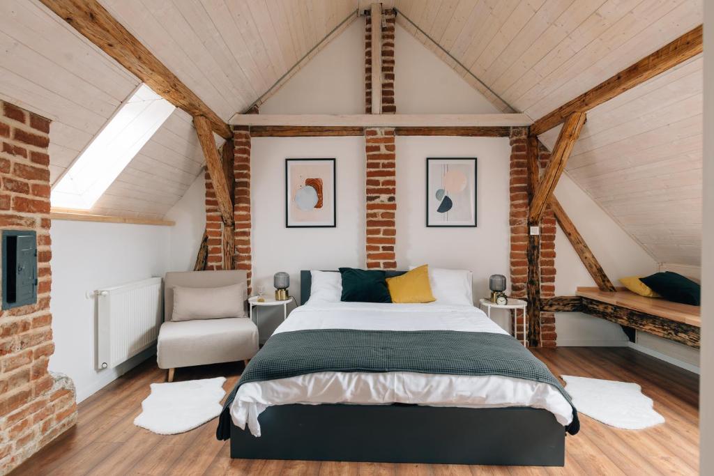 a bedroom with a bed and a chair in a attic at Principia Apartments in Turda