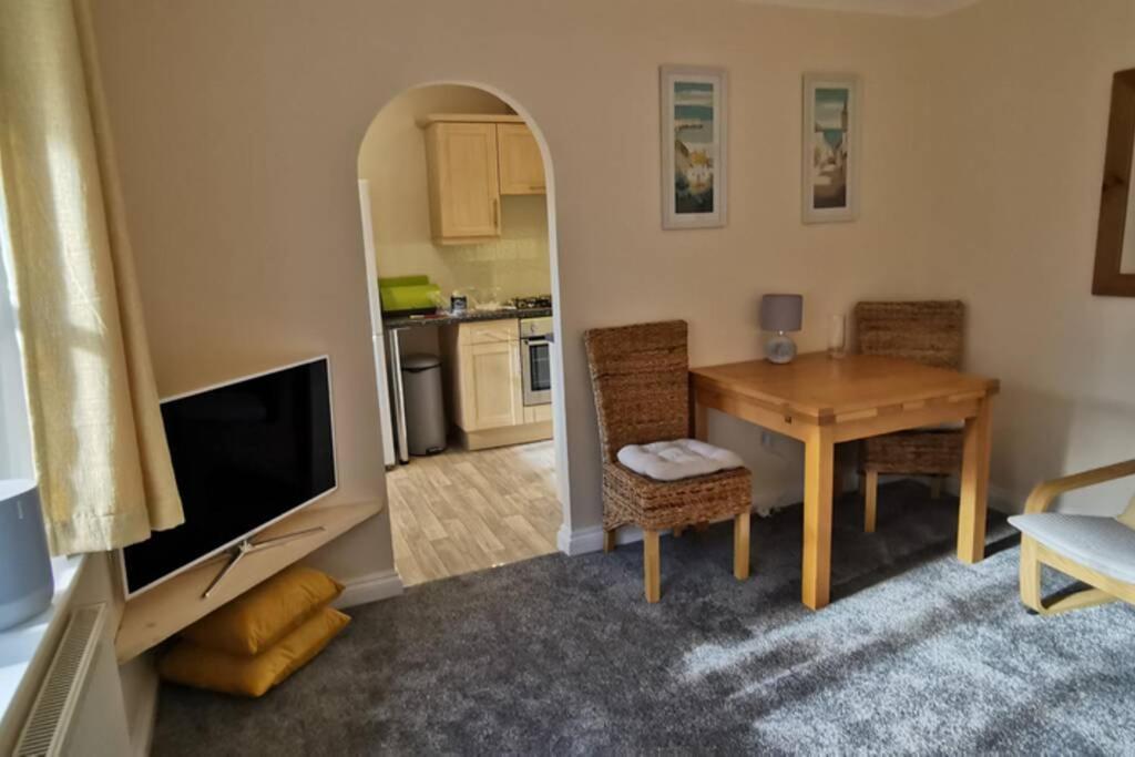 a living room with a table and a kitchen at The Honeypot - Cornish Apartment close to Eden Project & beaches in Par