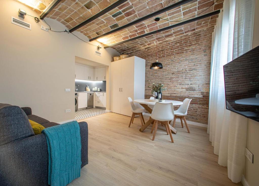 a living room with a table and a brick wall at Barcelona Touch Apartments in Hospitalet de Llobregat