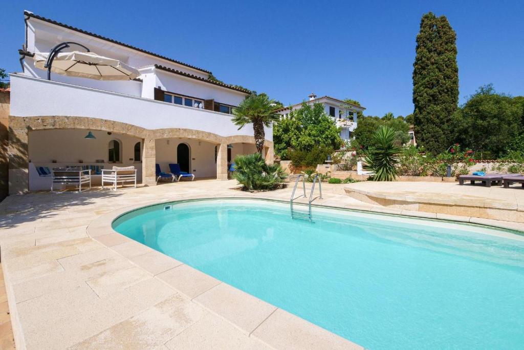 Villa con piscina frente a una casa en Villa Albatros, en Canyamel