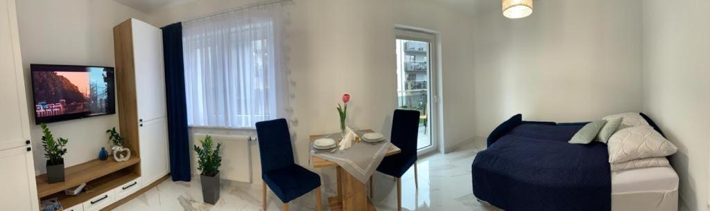 salon z łóżkiem, stołem i telewizorem w obiekcie Apartament Fordon przy Onkologii w Bydgoszczy