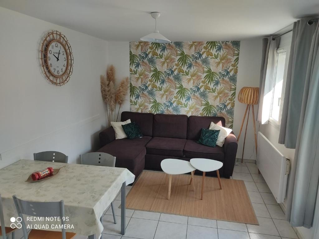 a living room with a couch and a table at Le Crotoy Plage Baie de somme Appt l'Aigrette in Le Crotoy