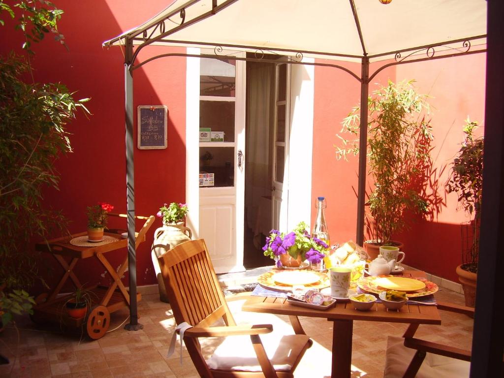 un patio con mesa y sombrilla en S'Attobiu B&B And Guest-Houses, en Teulada