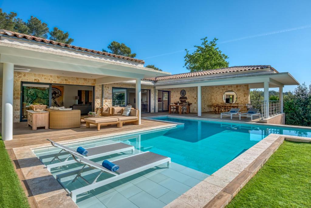 une maison avec une piscine et une maison dans l'établissement la villa miel, à Opio