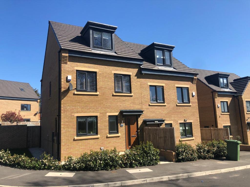 a brown brick house with a black roof at Roundhay House in Leeds