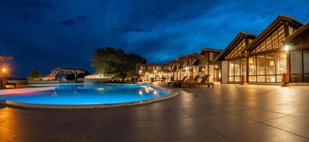 a large pool in a courtyard at night at Santa Rosa Pantanal Hotel in Pôrto Jofre
