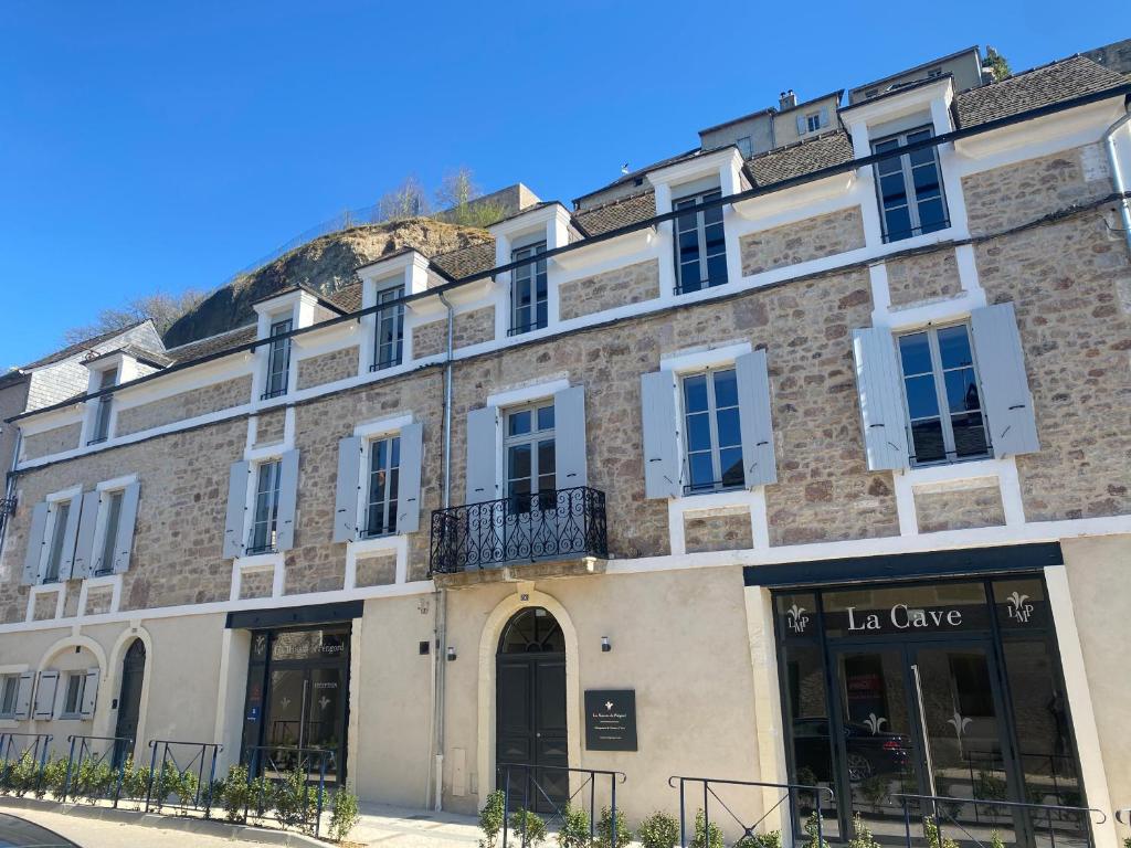 un gran edificio de ladrillo con ventanas blancas en Les Maisons du Périgord Côté 50, en Terrasson-Lavilledieu