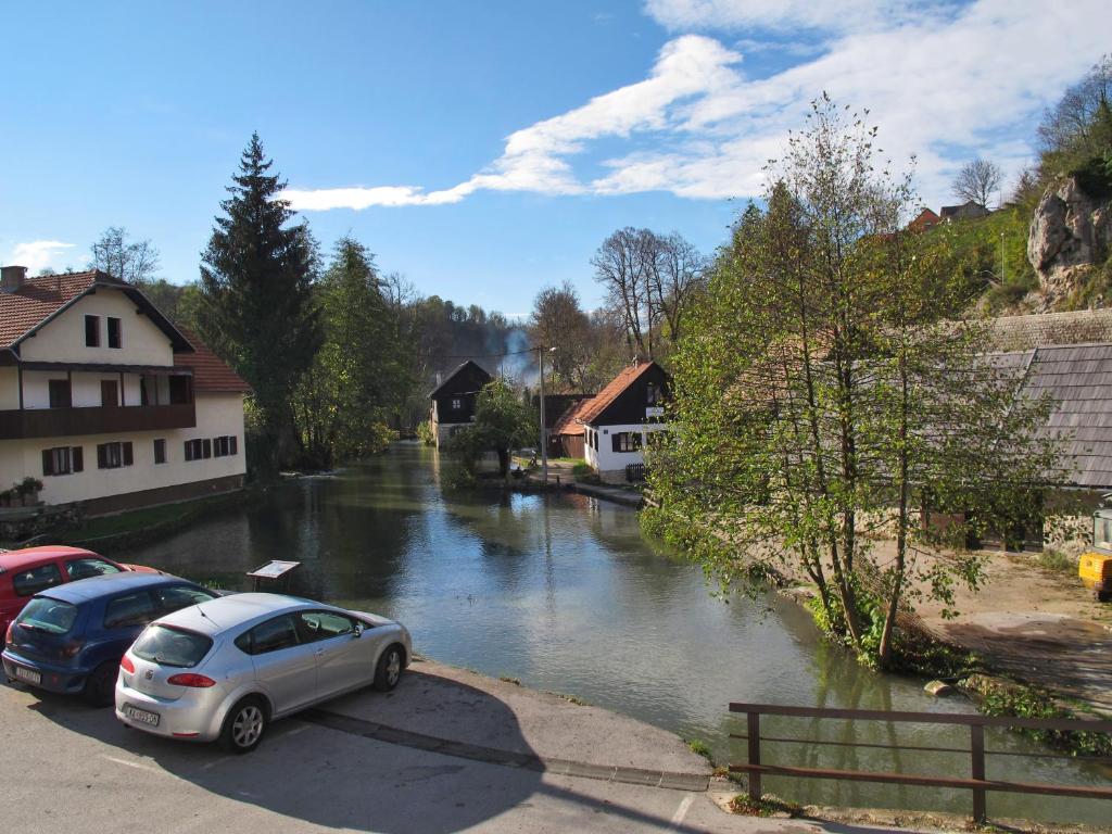 a car parked in a parking lot next to a river at Rooms Roza in Slunj