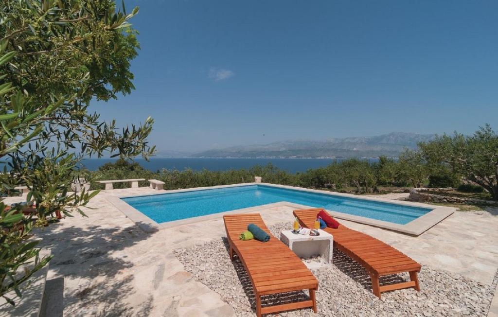 een zwembad met twee stoelen en een tafel en een zwembad bij Holiday home Glavica in Postira
