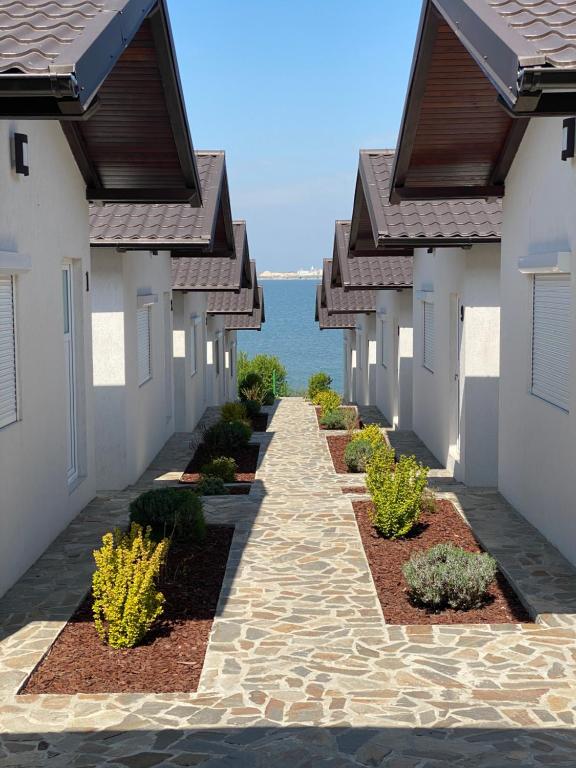 a walkway between two houses with the ocean in the background at La Casute Tasaul in Năvodari