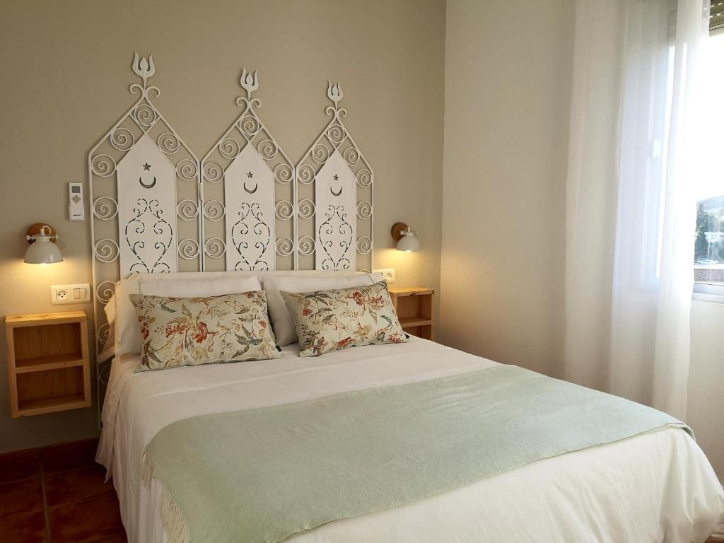 a bedroom with a large bed with a large headboard at Los Molinos in Sanlúcar de Guadiana