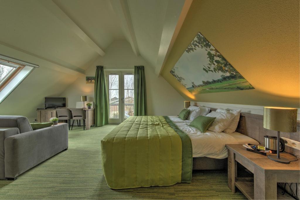 um quarto com uma cama, um sofá e uma mesa em De Willigen Logies em Vreeland