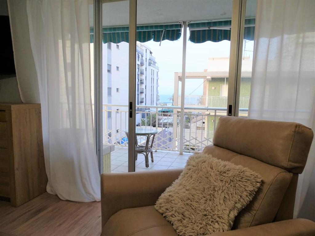 een woonkamer met een bank en uitzicht op een balkon bij DOROTHY Apartamento Playa de Gandia con vistas al mar 8 personas in Gandía