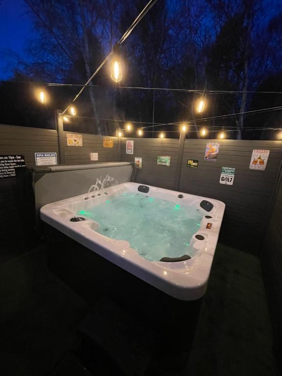 a large bath tub with blue water in it at Tigers Wood - 2 bed hot tub lodge with free golf, NO BUGGY in Swarland