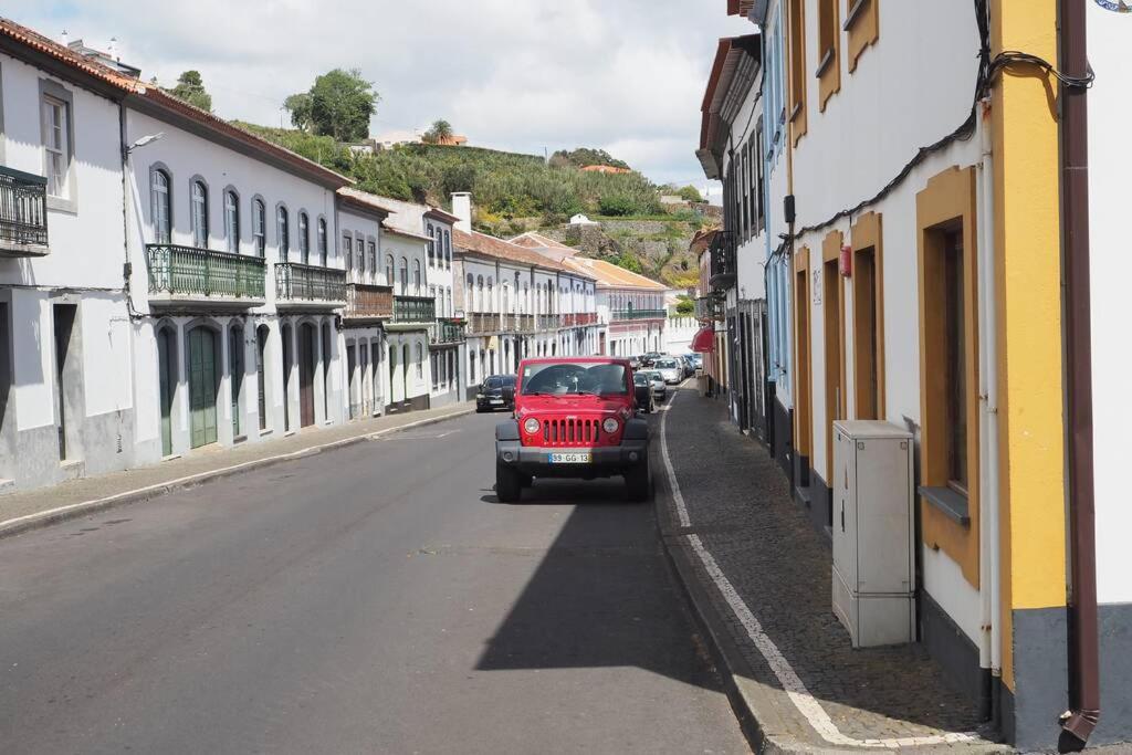 un coche rojo estacionado al lado de una calle en Saint Peter´s House, en Angra do Heroísmo