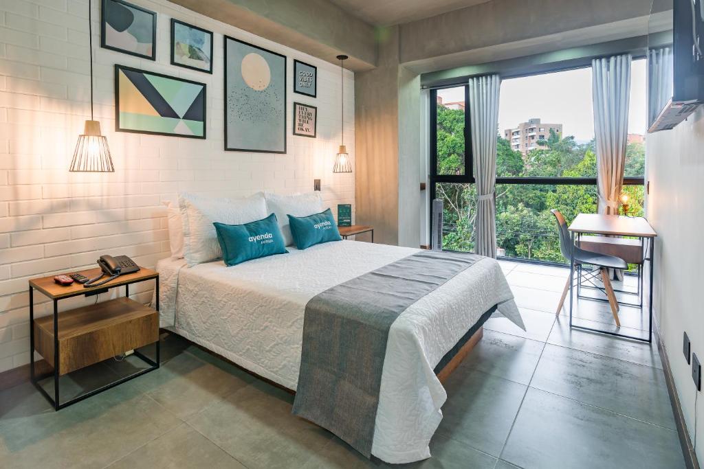 a bedroom with a bed and a window and a desk at Ayenda Loft 32 in Medellín