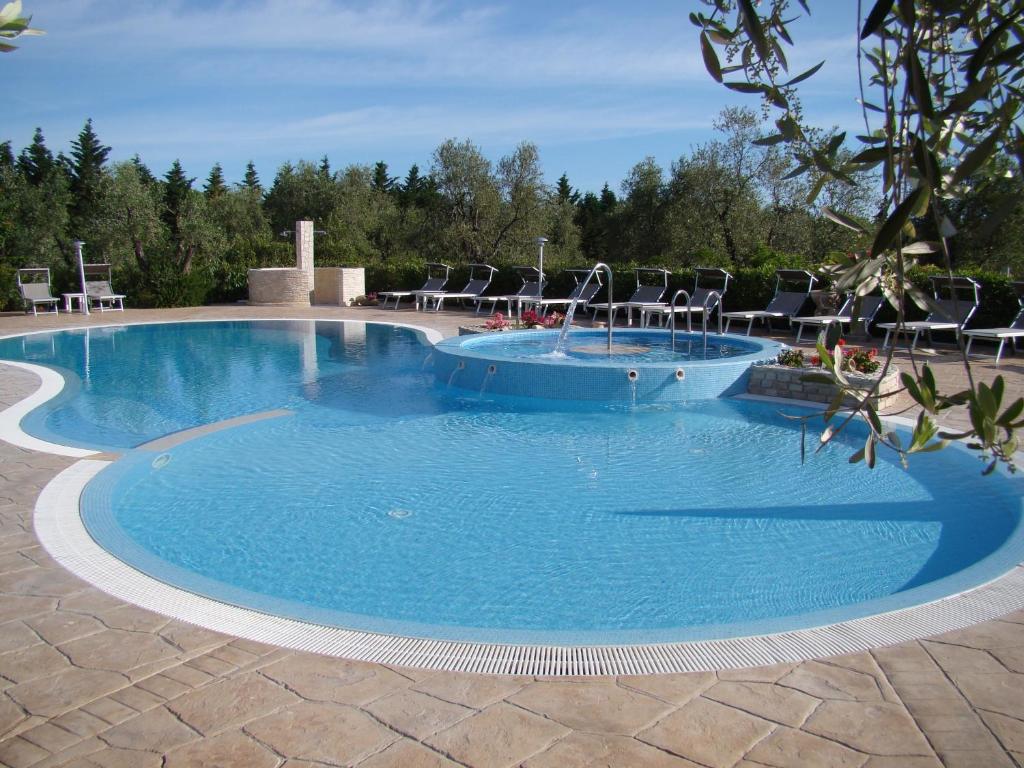 a large swimming pool with chairs in it at Agriturismo I Tesori del Sud Vieste, Puglia in Vieste