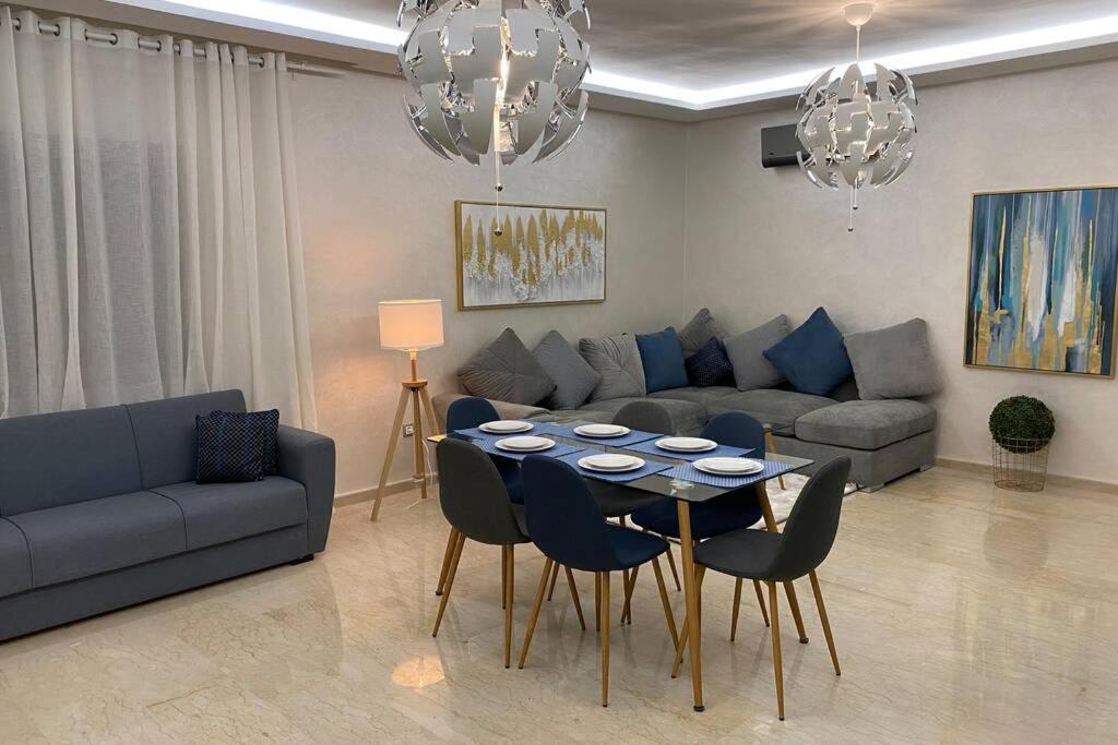 a living room with a couch and a table and chairs at Du Haut Standing au coeur du Parc et Plage à 180 m in Mohammedia