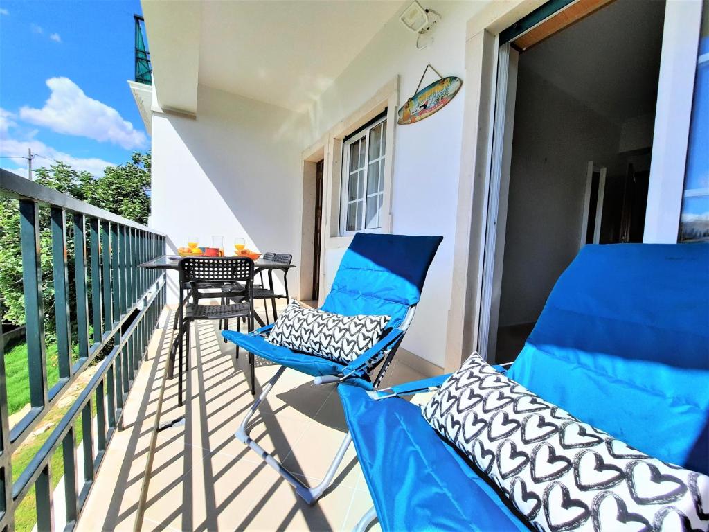 een paar blauwe stoelen op het balkon van een huis bij ALTIUM Cabanas in Cabanas de Tavira