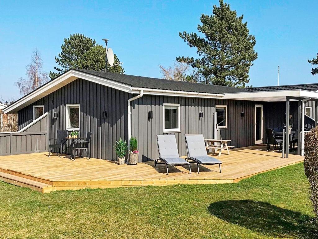 a house with a deck and two chairs on it at 6 person holiday home in Haderslev in Diernæs