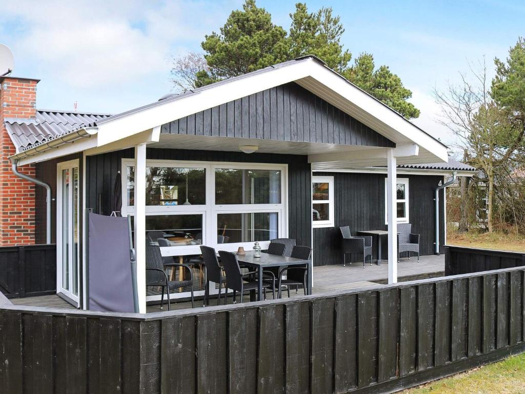 Nørre HurupにあるHoliday home Hadsund XXの木製デッキ(テーブル、椅子付)