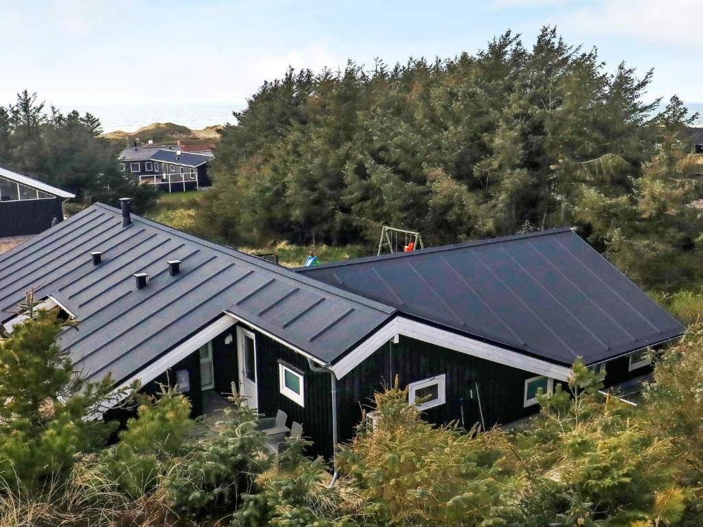 una casa negra con paneles solares en el techo en 10 person holiday home in L kken en Løkken