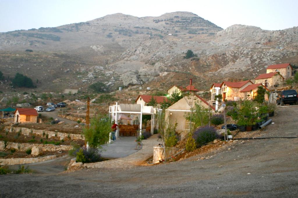 un piccolo villaggio con una montagna sullo sfondo di Soha Village Resort a Fālūghā