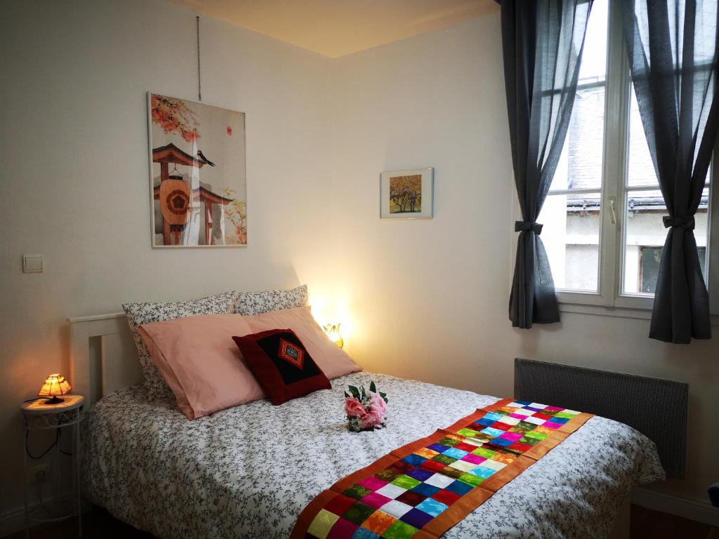 a bedroom with a bed with a colorful blanket at NICE APPARTEMENT in Amboise