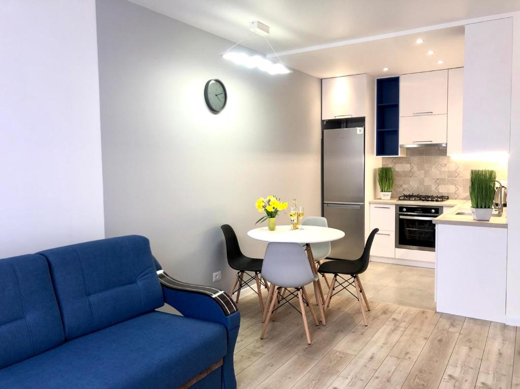 een woonkamer met een blauwe bank en een tafel bij VIP Apartment in a complex Semycvit in Lviv