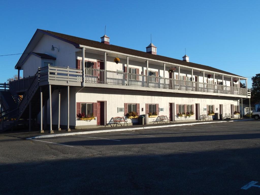 a large white building with a balcony on the side of it at Acadia Sunrise Motel in Trenton