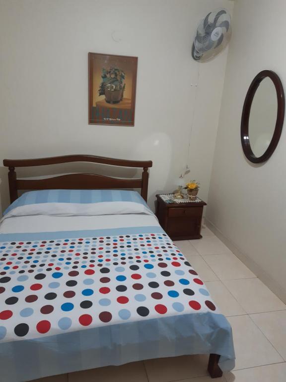 ein Schlafzimmer mit einem Bett mit einer Polka-Dot-Tagesdecke in der Unterkunft CAMBULOS in Cali