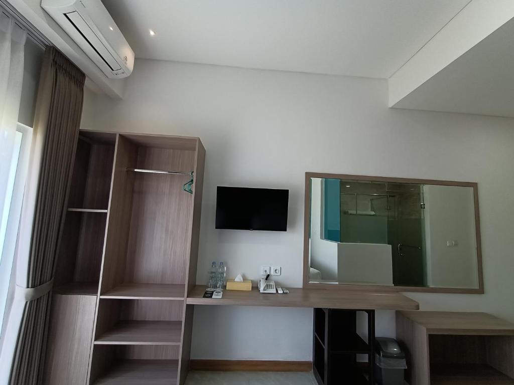 um quarto com uma secretária e um espelho grande em Grand Samota Hotel em Sumbawa Besar