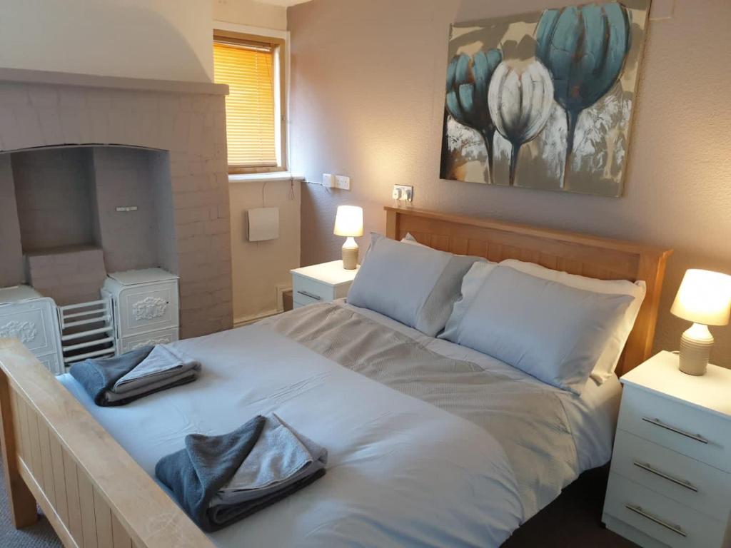 1 dormitorio con 1 cama con 2 toallas en The Peacock Inn en Loughborough