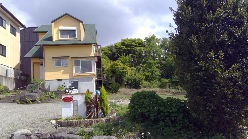 a yellow house with a bike parked in front of it at Healing space tajima Shinmoe in Kirishima