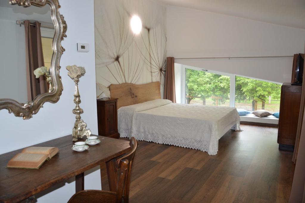 a bedroom with a bed and a table with a mirror at Agriturismo Castolda in Treviglio