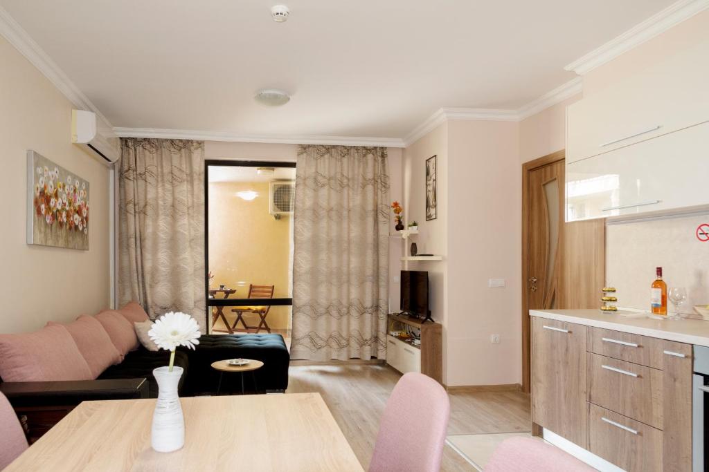 ein Wohnzimmer mit einem Sofa und einem Tisch in der Unterkunft Apartment EliMar in Burgas City