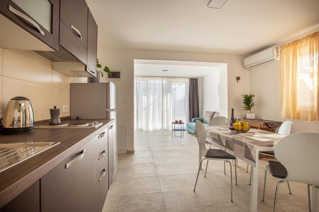 uma cozinha e sala de jantar com mesa e cadeiras em Apartaments Punta Relax em Umag